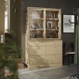 A modern wooden cabinet named TONSTAD in oak finish with glass doors, displaying decorative items, and six drawers for storage.
