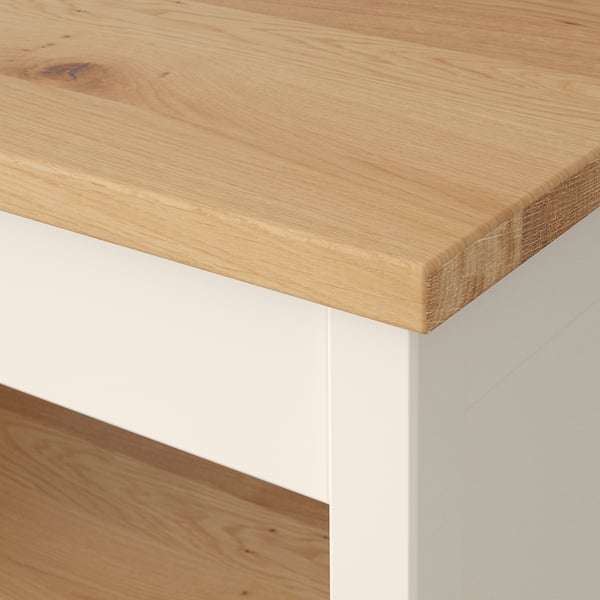 Close-up of a wood-topped furniture with smooth, even grain and faults, supported by clean white legs.