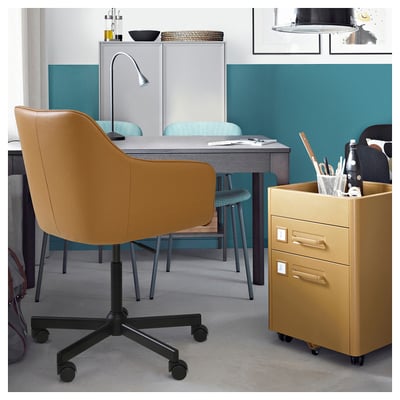 TOSSBERG office: mustard swivel chair, gray desk, lamp, papers, blue chairs, yellow filing cabinet, teal accent wall.