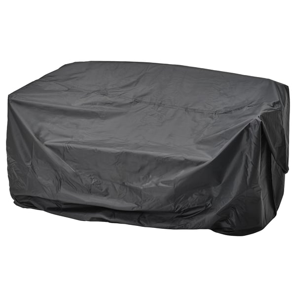 A black TOSTERÖ outdoor furniture cover, waterproof, rectangular, with elastic straps for securing.