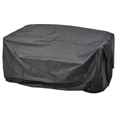 A black TOSTERÖ outdoor furniture cover, waterproof, rectangular, with elastic straps for securing.