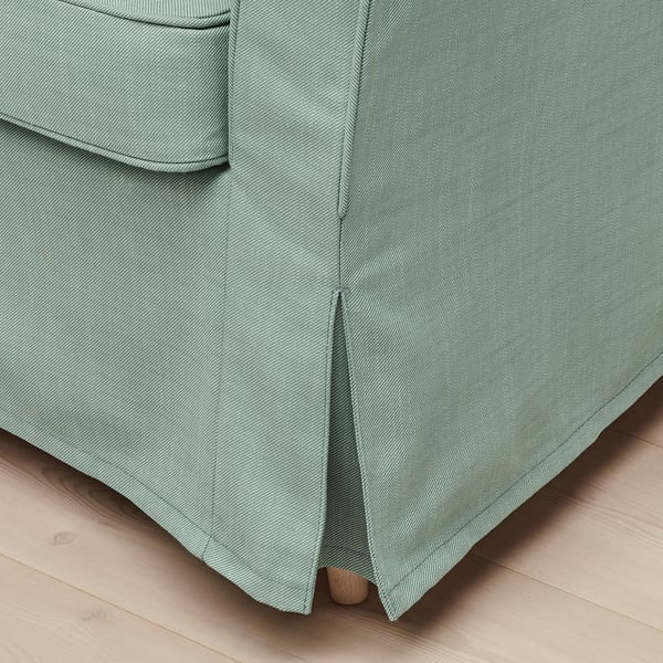 Close-up of modern, green armchair detail, showing quality fabric and stitching.