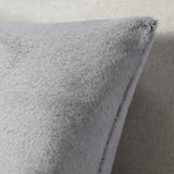 Soft, plush grey cushion with fluffy texture, made from recycled polyester, zipper closure.