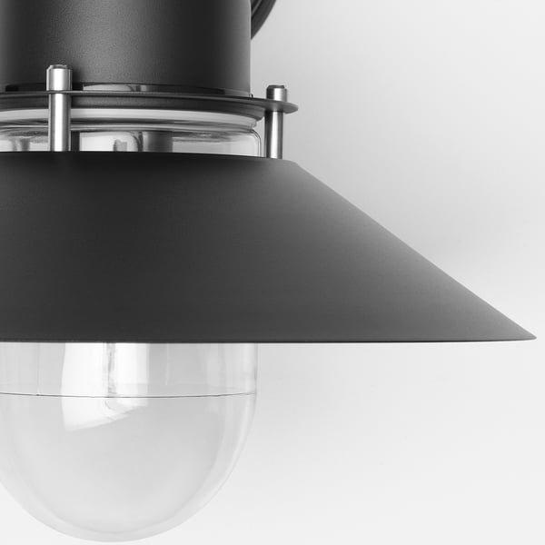 Black outdoor wall lamp with clear glass shade, sleek design, sturdy metal construction.