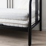 Black metal bed frame with white mattress and sheets, perfect for spaces with up to 16 cm mattress depth.