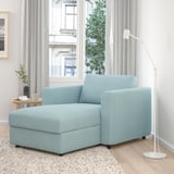 Modern living room with light blue VIMLE sectional sofa, large window, natural light, wooden floor, rug, side table, plant, lamp, serene setting.