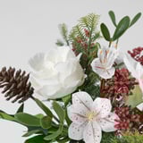 Lush artificial flowers, white lilies, red berries & pinecones; vivid, lifelike, arranged beautifully.