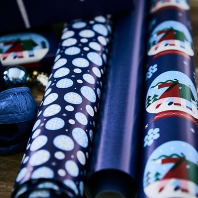 Blue gift wrap roll with white snowflake design. Perfect for holiday gifting.