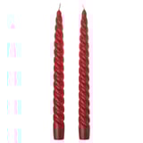 Two red twisted candles. Simple, festive, spiral design. Made from cotton and wax. Perfect for holiday decor.