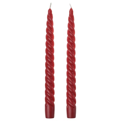 Two red twisted candles. Simple, festive, spiral design. Made from cotton and wax. Perfect for holiday decor.