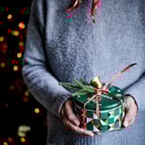 Green VINTERSAGA can with red ribbon and lights.