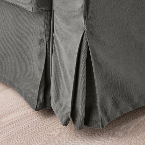 Close-up of gray textured sofa-bed fabric, showcasing quality pleats & clean lines.