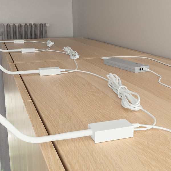 Wooden counter with multiple ikea YTBERG slim lamps. Lamps have flexible gooseneck arms angled to direct soft light, ideal for tasks and crafting.