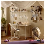 Configuração de home office com mesa ADILS , com decoração, plantas e equipamentos de ginástica.