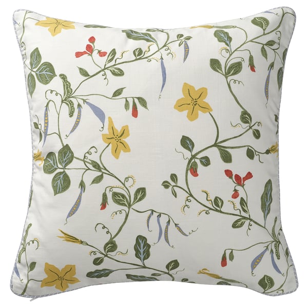 Almofada quadrada branca com flores amarelas, folhas verdes e debrum azul claro.