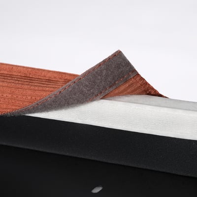 Um close-up de uma pilha de capas de cadeira de tecido vermelho e cinza em uma superfície preta.