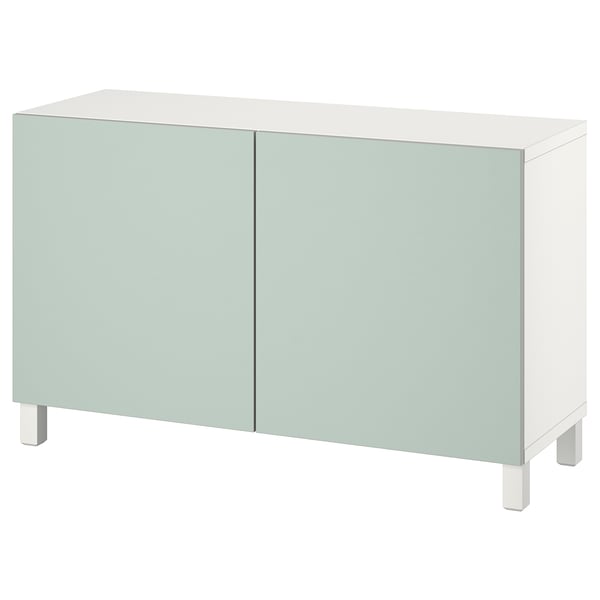 Um aparador ikea BESTÅ em verde claro com prateleiras reguláveis. Tem linhas limpas e um design minimalista com quatro pernas.