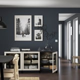 Sala de jantar moderna com aparador BESTÅ branco com pratos, canecas e artigos decorativos. Fotos em preto e branco adornam a parede cinza escuro.