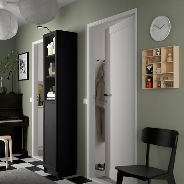 Uma sala de estar moderna com uma estante BILLY em preto na entrada.