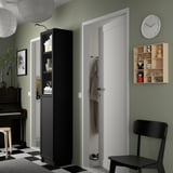 Uma sala de estar moderna com uma estante BILLY em preto na entrada.