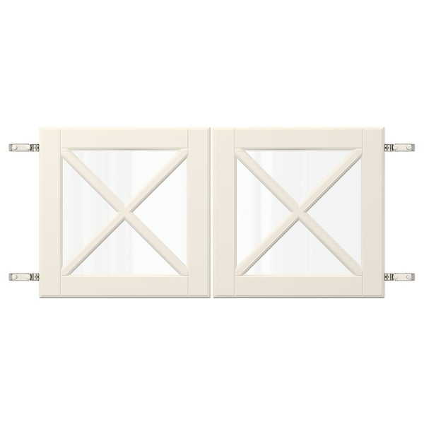 Duas portas de armário brancas com painéis de vidro com um design de barra transversal em x, fixadas por dobradiças de metal.