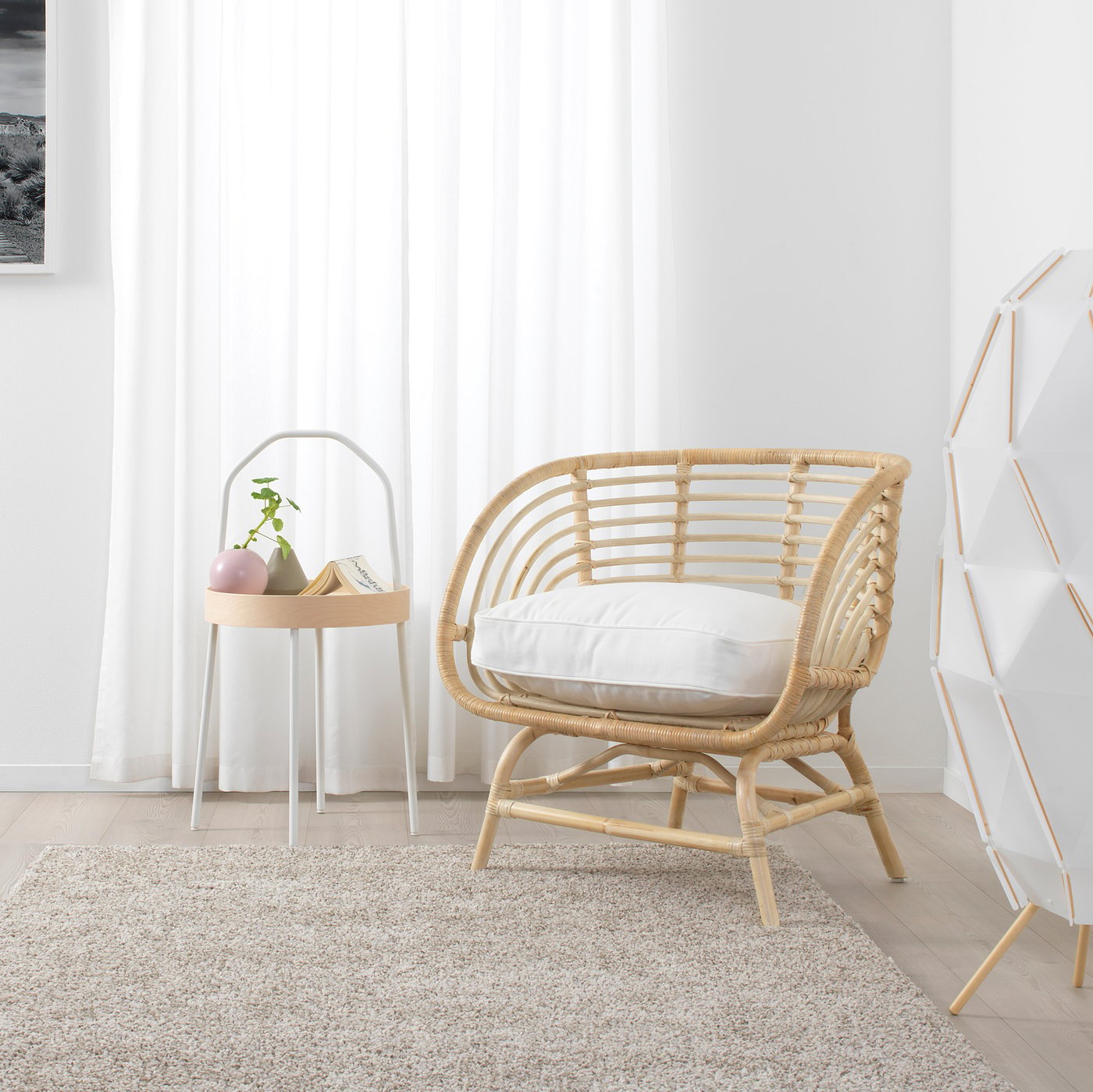 Cadeira de vime BUSKBO com almofada, mesa e suporte para guarda-chuva em ambiente interno aconchegante.