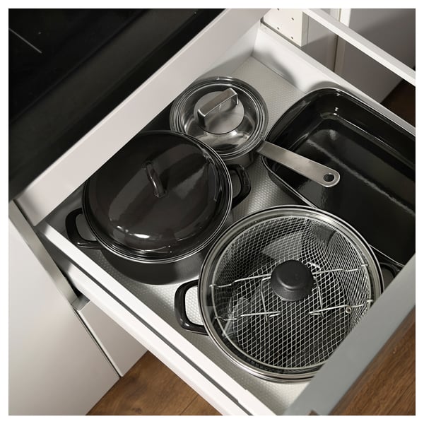 Gaveta de cozinha com panelas e frigideiras, cores preto e prata, esmalte e aço inoxidável.