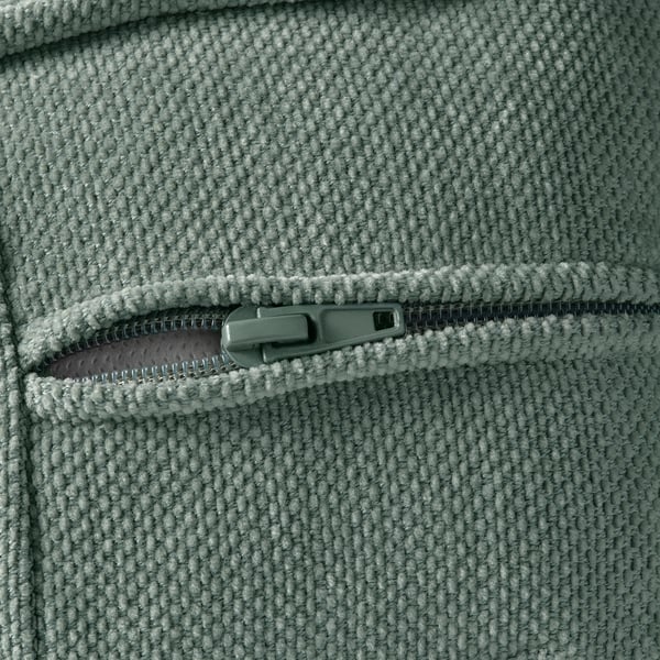 Close-up de um tecido cinza macio com um puxador de zíper, mostrando uma textura de pelúcia de alta qualidade e detalhe de zíper resistente.