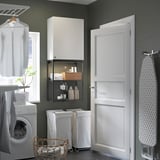 Moderno conjunto de lavandaria com armário, máquina de lavar e cesto ENHET para consumíveis.