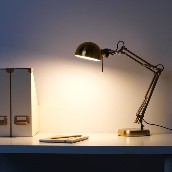 Candeeiro de mesa; braço e cabeça ajustáveis; luz brilhante na mesa.