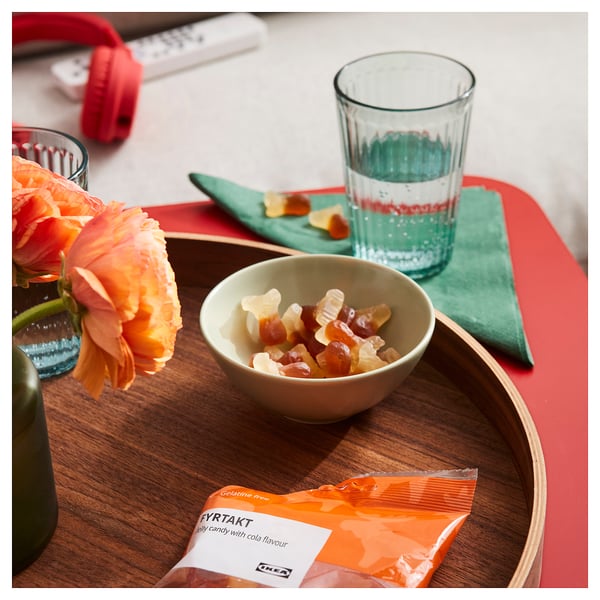 Bandeja de madeira com balas de goma, balas de cola FYRTAKT, água e flor. Pronto para comer.