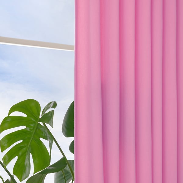 Cortinas rosa brilhante pendem de uma janela, emoldurando uma planta verde exuberante com folhas grandes, permitindo que a luz do dia filtrada ilumine suavemente a cena.