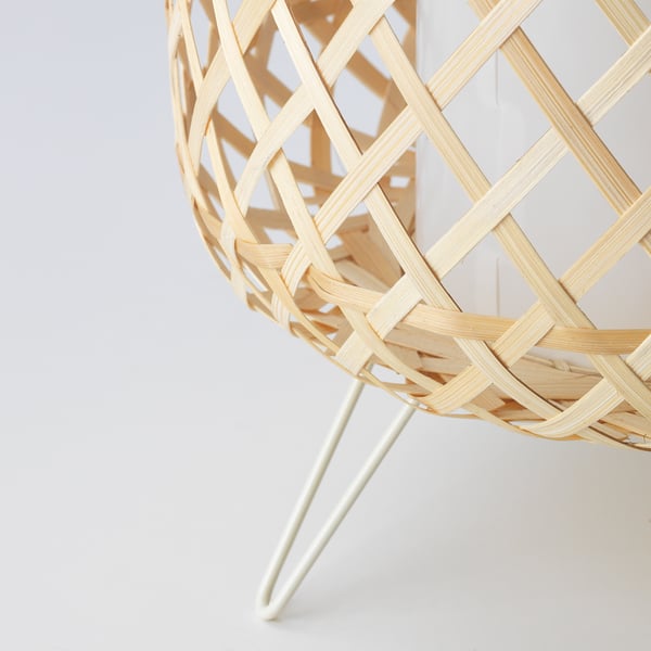 Lâmpada pendente de bambu tecida à mão, artisticamente trabalhada com padrão de treliça intrincada, lançando luz quente.