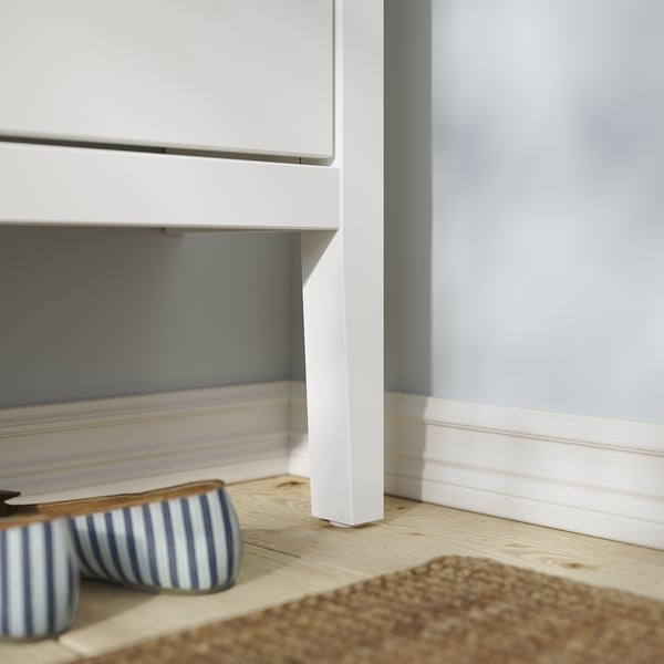 Sapateira branca GULLABERG com chinelos listrados. Design moderno, minimalista, piso de textura de madeira.