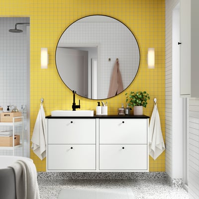 Casa de banho moderna com lavatório HAVBÄCK, parede de azulejos amarelos, espelho grande e arrumação.