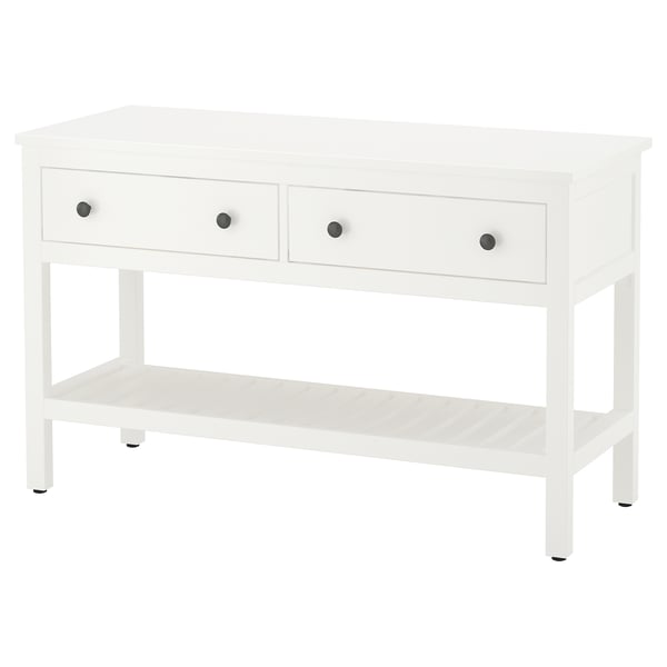 Uma consola HEMNES branca. Possui três gavetas com puxadores prateados e uma prateleira aberta. O design é simples e funcional.