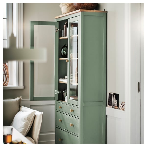 Armário com porta de vidro verde HEMNES com amortecedores, prateleiras reguláveis e decoração.