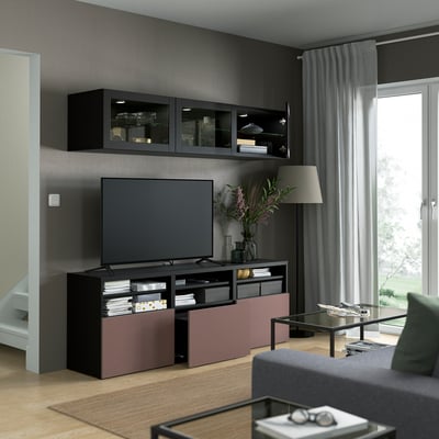 Sala de estar moderna com armários de vidro montados na parede, TV de tela plana e unidade de mídia colorida com armazenamento.