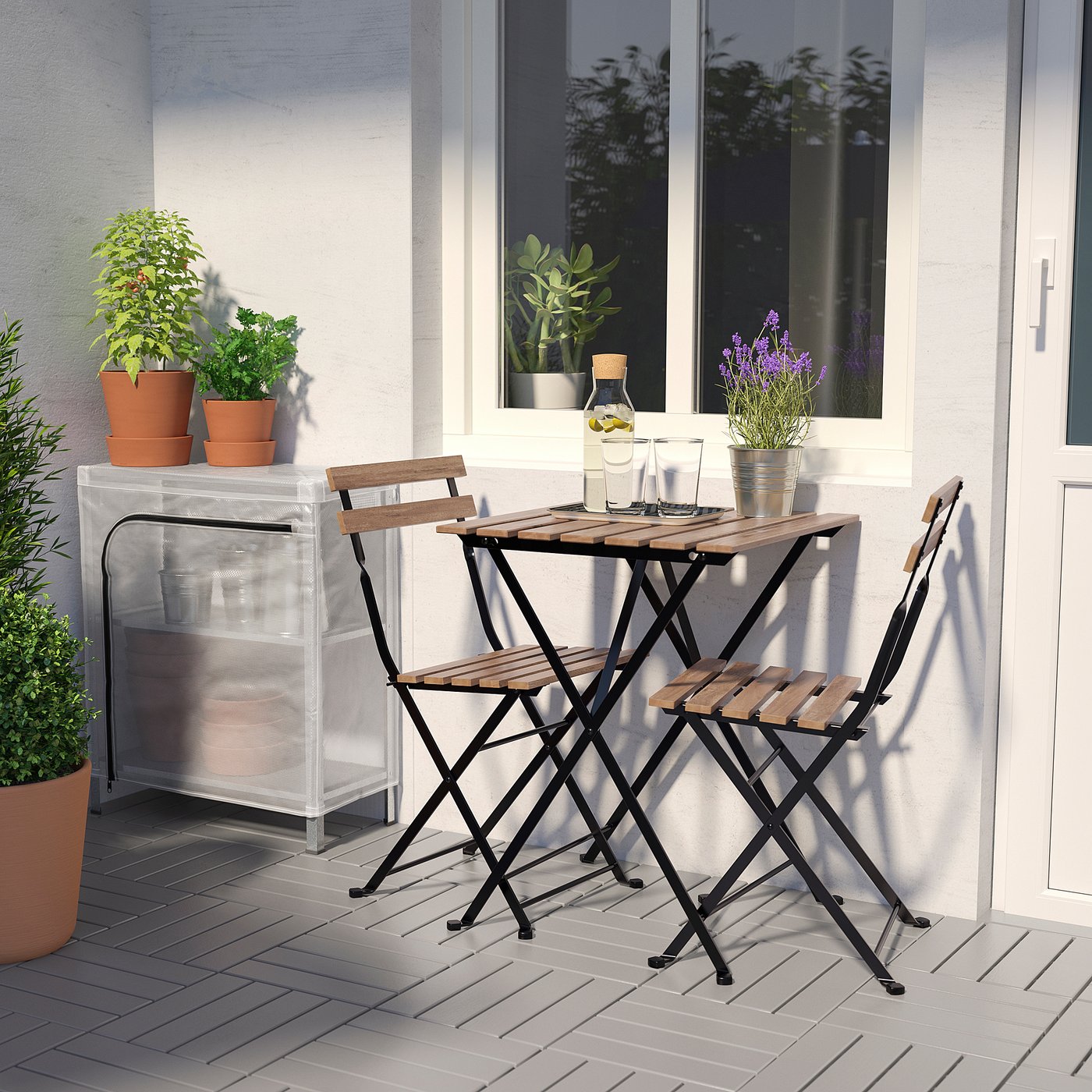 Conjunto de mesa pequena ao ar livre com 2 cadeiras dobráveis. Cercado por vasos de plantas no convés.