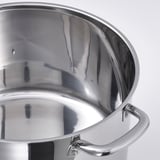 Close-up de panelas de aço inoxidável polido, borda e alça robusta.