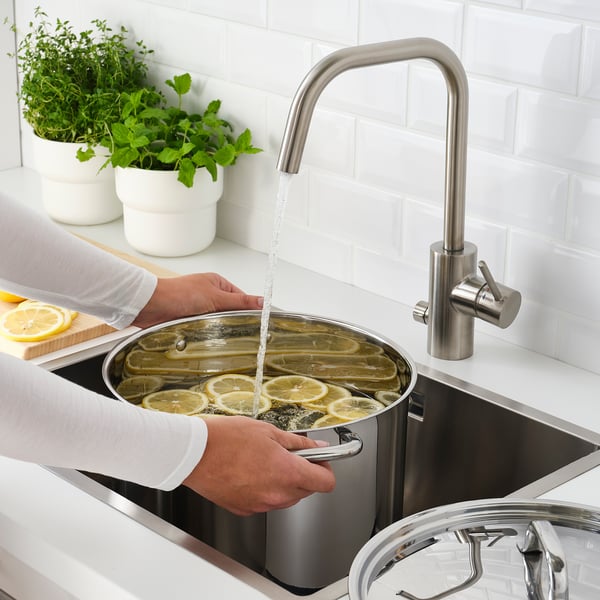 Cozinheiro ferve ervas na cozinha