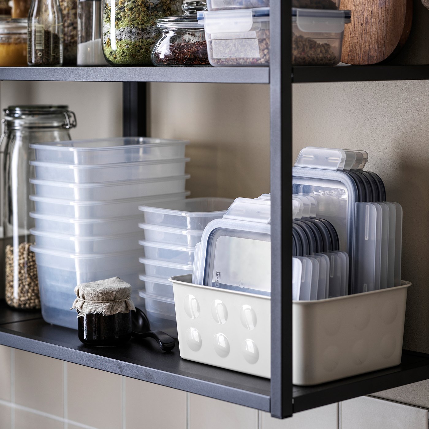 Prateleira de despensa organizada com recipientes, tampas e frascos de alimentos em plástico transparente IKEA 365+.