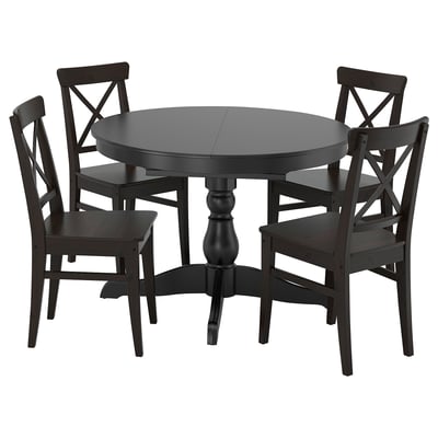 Mesa de jantar extensível redonda preta com quatro cadeiras correspondentes. Construção em madeira maciça, design clássico, bancos de encosto alto.