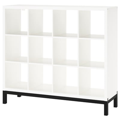 Estante KALLAX em branco com estrutura inferior. Tem uma forma quadrada moderna com linhas limpas e várias prateleiras abertas.