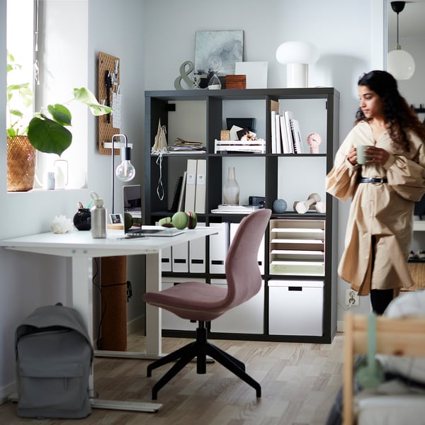Home office com prateleira KALLAX, livros, mesa, cadeira e mochila.