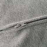 Detalhe de zíper de tecido tipo tweed, possivelmente de um sofá ou bolsa, mostrado em close-up.