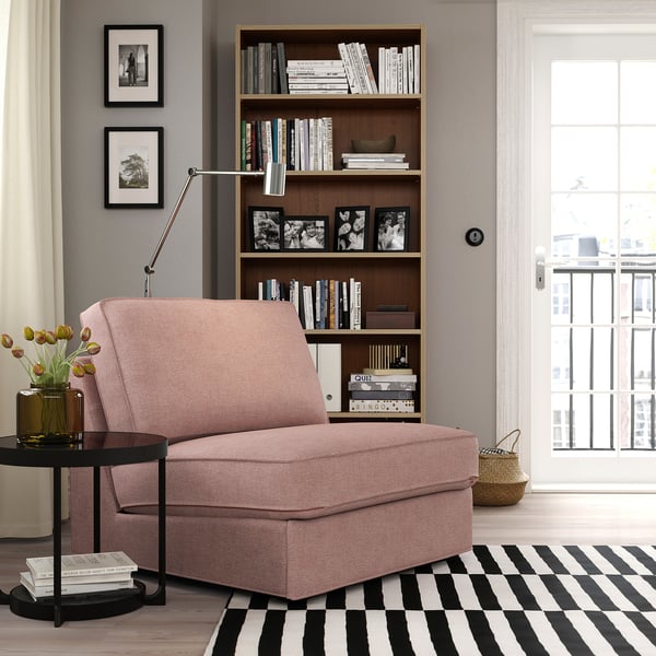 Sofá-cama cor-de-rosa KIVIK na acolhedora sala de estar com estante e tapete. Alternativamente, sofá-cama rosa KIVIK em pequena sala de estar com estante e tapete.