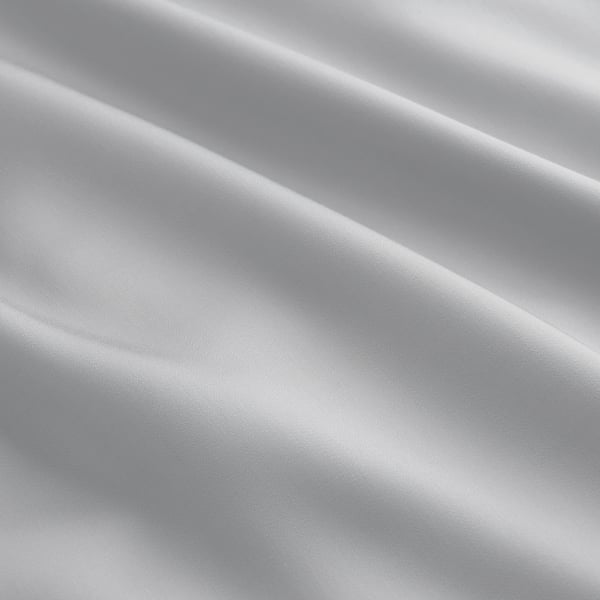 Capa de colcha cinza claro lisa e lustrosa exibindo tecido de liocel fino. Textura suave e convidativa, sugerindo conforto e qualidade.