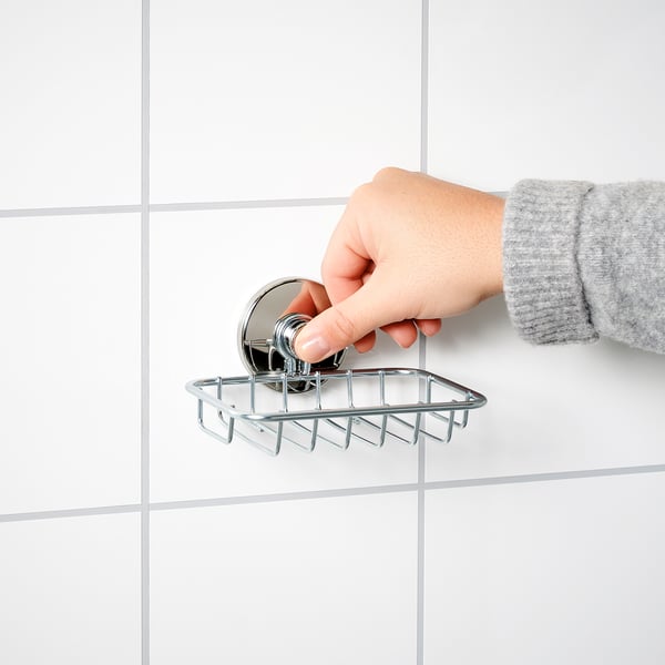 Anexar à mão a saboneteira KROKFJORDEN à parede de azulejos brancos. O prato é cromado, retangular com ventosas.