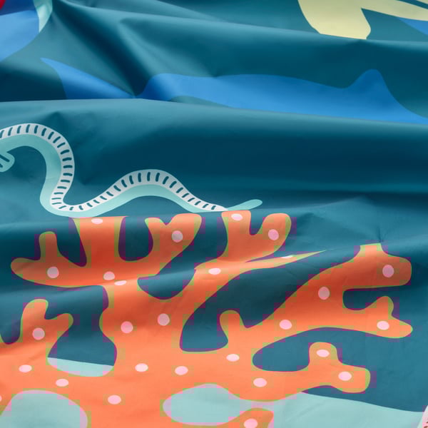 Tenda de cama com tema oceânico com padrões de corais e criaturas marinhas.
